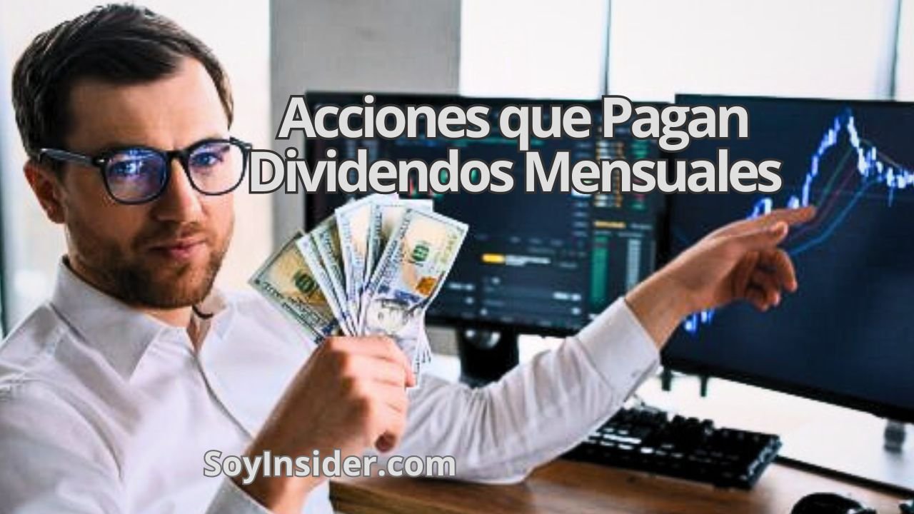 Un hombre con gafas sostiene billetes de dólares en una mano mientras señala un monitor con gráficos financieros en un entorno de oficina moderna. En el recuadro de la imagen se lee: "Acciones que Pagan Dividendos Mensuales". En la esquina inferior derecha aparece el texto "SoyInsider.com".