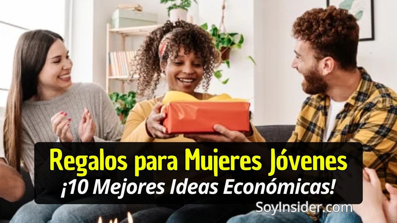 Una joven mujer sonriente recibe un regalo envuelto en papel rojo mientras otras personas a su alrededor aplauden y celebran con alegría en una sala acogedora y bien iluminada. Texto en el recuadro: "Regalos para Mujeres Jóvenes, ¡10 Mejores Ideas Económicas!", mientras que en la esquina inferior derecha aparece el texto "SoyInsider.com".