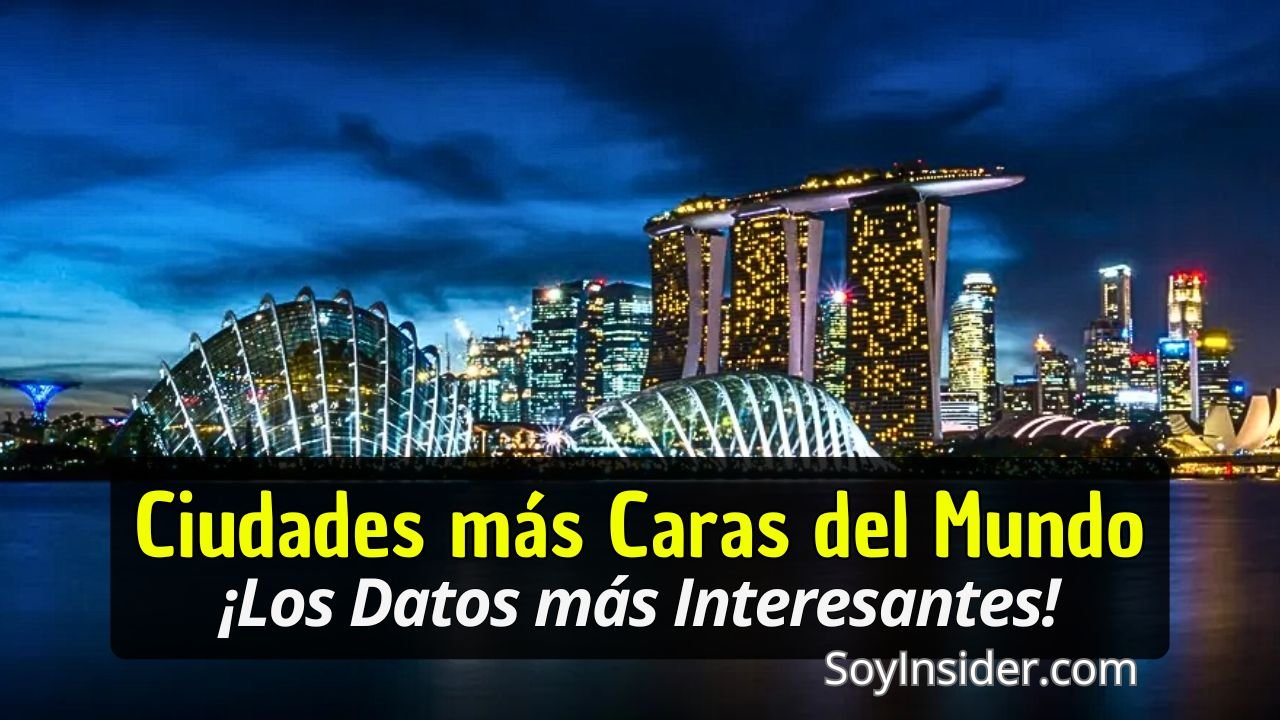 Imagen de un paisaje urbano nocturno con rascacielos iluminados, incluyendo el icónico Marina Bay Sands en Singapur. En el primer plano, un cuerpo de agua refleja las luces de la ciudad, mientras estructuras futuristas como el biodomo destacan bajo un cielo azul oscuro. En la parte inferior, un recuadro negro contiene el texto destacado: "Ciudades más Caras del Mundo, ¡Los Datos más Interesantes!". En la esquina inferior derecha aparece el texto "SoyInsider.com".