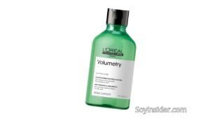 Imagen de una botella verde con tapa negra del champú L’Oréal Professionnel Volumetry. La etiqueta blanca en la parte frontal detalla el producto como un champú profesional diseñado para cabello fino, proporcionando un efecto de volumen antigravedad. El envase tiene un diseño elegante y profesional, resaltando la calidad del producto. En la parte inferior derecha de la imagen aparece la marca "SoyInsider.com".