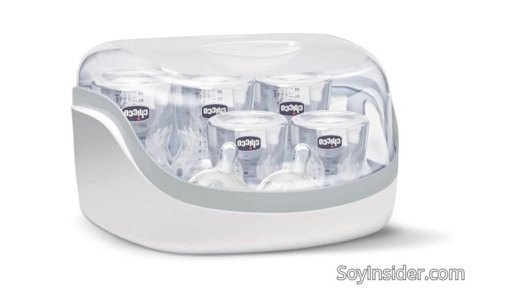 Esterilizador de biberones Chicco con diseño compacto y moderno, ideal para mantener los biberones y accesorios del bebé libres de gérmenes. Capacidad para varios biberones, fabricado en plástico resistente con tapa transparente que permite visualizar el contenido. El logotipo de la marca "Chicco" se muestra claramente en los biberones esterilizados. Texto visible en la imagen: "SoyInsider.com".