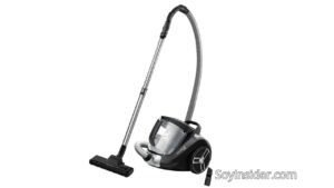 Imagen de una aspiradora sin bolsa Rowenta Cyclonic Power XXL RO4825. La aspiradora tiene un diseño moderno en color negro con detalles plateados, un tubo metálico telescópico y una manguera flexible gris. Incluye un cepillo principal y un accesorio adicional para limpieza de rincones. Texto visible en la imagen: "SoyInsider.com".