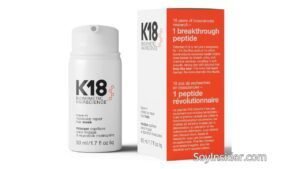 Imagen de una mascarilla capilar K18 Biomimetic Hairscience en su presentación de 50 ml. El envase es blanco, con detalles en naranja y el logo de la marca en negro. El texto del envase explica que es una mascarilla reparadora molecular para el cabello, que no requiere enjuague. Texto visible en la imagen: "SoyInsider.com".