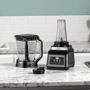 Imagen de la Ninja Batidora de vaso 2 en 1 de 1200 W mostrando su diseño moderno, jarra de 2,1 litros, vaso portátil de 700 ml, botones de 3 programas automáticos y 4 ajustes manuales con tecnología Auto-iQ, ideal para smoothies, salsas y batidos, destacada en opiniones de usuarios satisfechos.