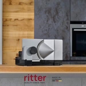 Cortadora de alimentos eléctrica Ritter E 18 para zurdos en color plateado, diseño compacto y moderno, ideal para rebanar pan, embutidos, quesos y más con precisión profesional.