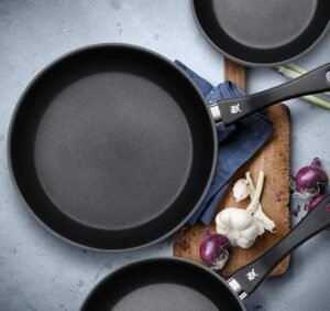 Imagen del juego de 3 sartenes WMF Devil de 20, 24 y 28 cm, fabricadas en acero inoxidable con revestimiento antiadherente, ideal para cocinar sin que los alimentos se peguen y obtener un rendimiento duradero en la cocina.
